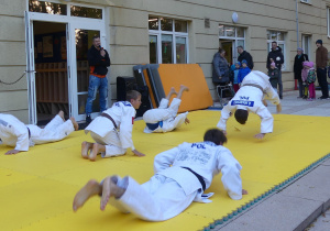 Grupa zawodników judo przedstawia pokaz swoich umiejętności.