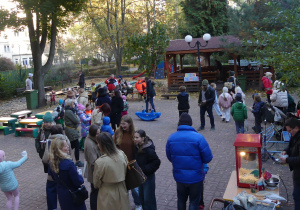 Dzieci wraz z rodzicami biorą udział w pikniku.