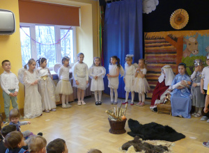 Dzieci przebrane za św. Józefa, Marię oraz aniołków i pastuszków przedstawiające jasełka.