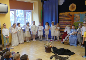 Dzieci w przebraniu Św. Józefa, Maryję oraz Aniołków i Pastuszków przedstawiają jasełka.